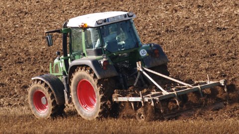 Ein Trecker pflügt ein Feld
